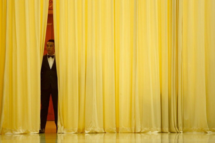 A hotel employee stands behind a curtain before Malaysia's Defence Minister Hishammuddin arrives for a news conference near Kuala Lumpur