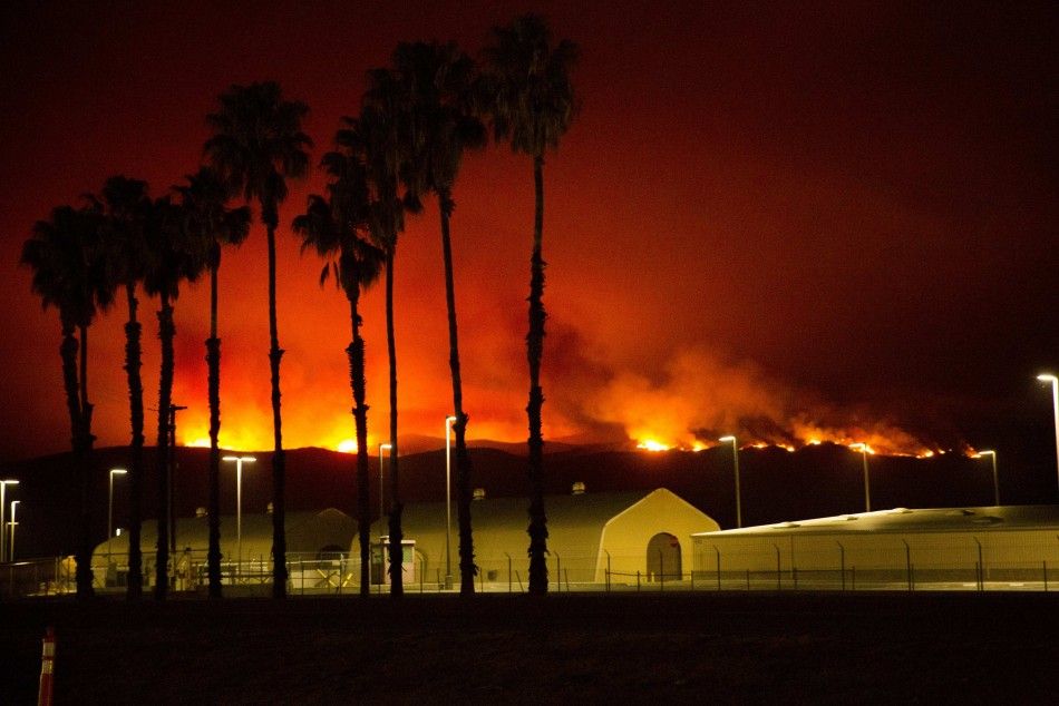 The Las Pulgas Fire is seen burning near military structures at Camp Pendleton, California in this handout photo taken May 15, 2014 and released to Reuters May 16, 2014 by the USMC. The Las Pulgas Fire is one of four fires at Camp Pendleton Marine Base no