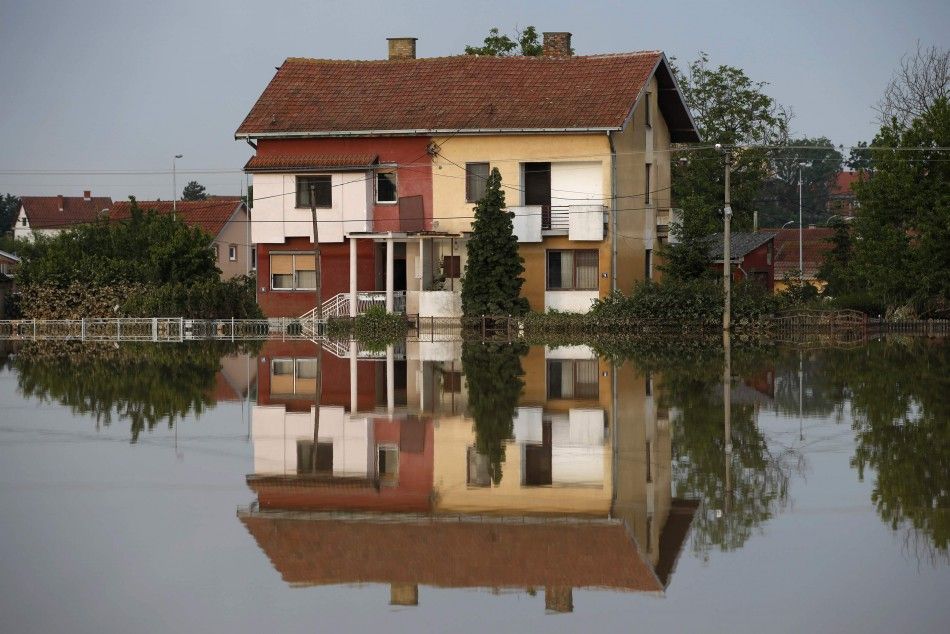 A house is seen reflected in flood waters in Obrenovac, southwest of Belgrade, May 20, 2014. Soldiers and energy workers stacked thousands of sandbags overnight to protect Serbias biggest power plant from flood waters expected to keep rising after the he