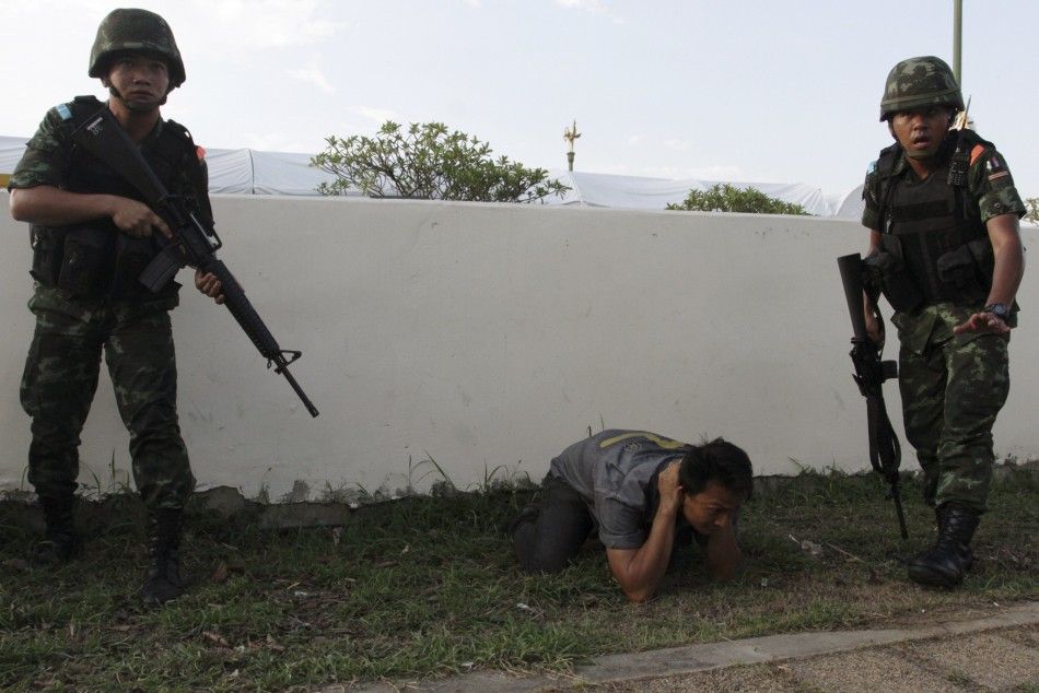 A man gets to the ground after Thai soldiers entered the pro-government quotred shirtquot groups encampment, following the coup, in Nakhon Pathom province on the outskirts of Bangkok May 22, 2014. Thailands army chief General Prayuth Chan-ocha seize