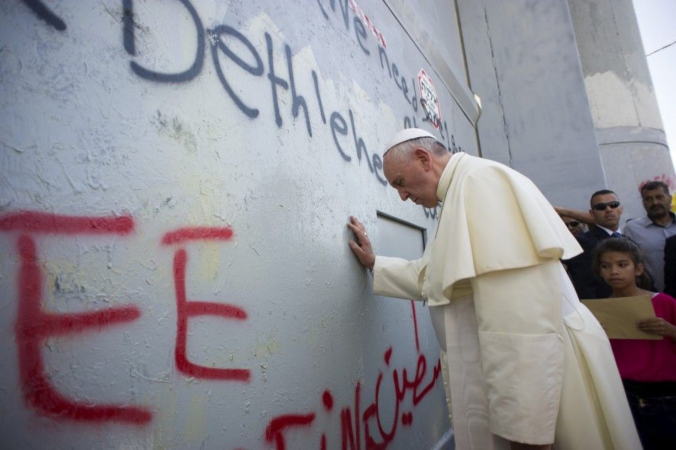Pope Francis touches the wall that divides Israel from the West Bank, on his way to celebrate a mass in Manger Square next to the Church of the Nativity in the West Bank city of Bethlehem May 25, 2014. Pope Francis made an impassioned plea for peace on a 
