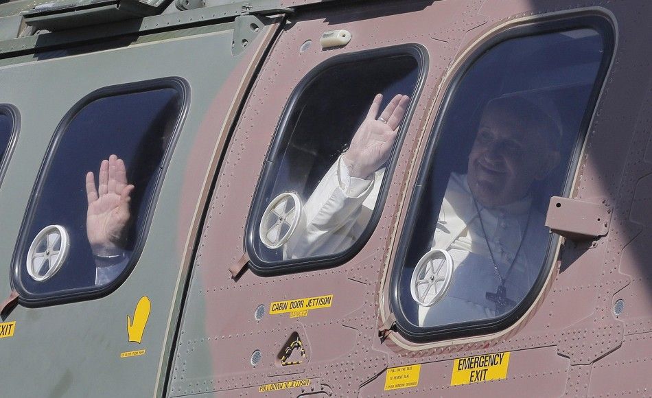 Pope Francis, onboard a helicopter, waves as leaves the West Bank town of Bethlehem May 25, 2014. Pope Francis made a surprise stop on Sunday at the wall Palestinians abhor as a symbol of Israeli oppression, and later invited presidents from both sides of