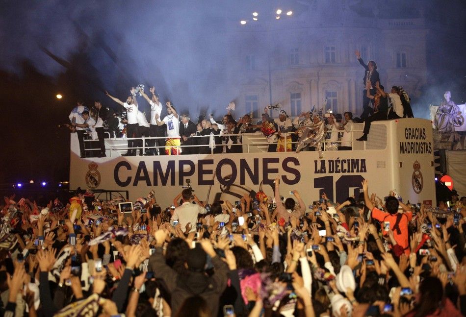 Real Madrid players celebrate on top of an open bus 