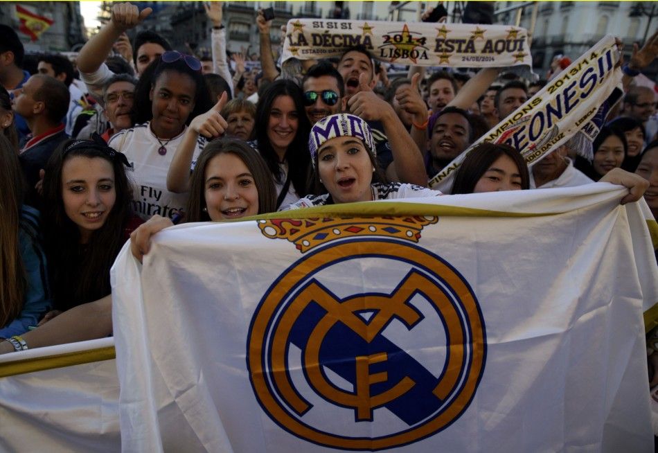 Real Madrids fans cheer as they wait for the arrival of the team at Madrids Community headquarters for victory celebrations 