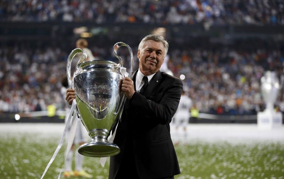 Real Madrids coach Carlo Ancelotti poses with  the Champions League trophy