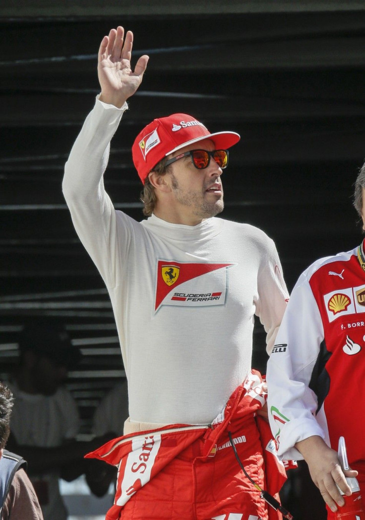 Ferrari Formula One driver Fernando Alonso of Spain waves as he arrives at the third practice session of the Monaco Grand Prix in Monaco May 24, 2014. REUTERS/Robert Pratta