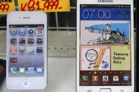 Apple's iPhone (L) and Samsung Galaxy Note are displayed at a shop in Tokyo