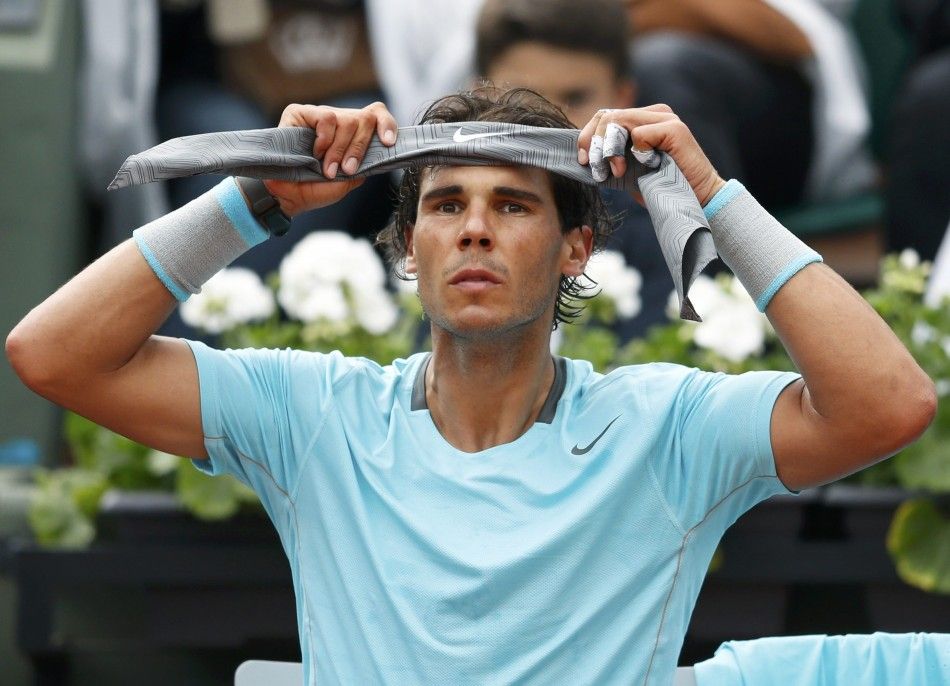 Rafael Nadal of Spain puts on a headband during his mens singles match against Robby Ginepri of the U.S. at the French Open tennis tournament at the Roland Garros stadium in Paris May 26, 2014.