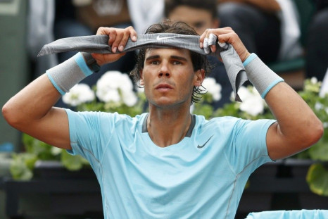 Rafael Nadal of Spain puts on a headband during his men's singles match against Robby Ginepri of the U.S. at the French Open tennis tournament at the Roland Garros stadium in Paris May 26, 2014.