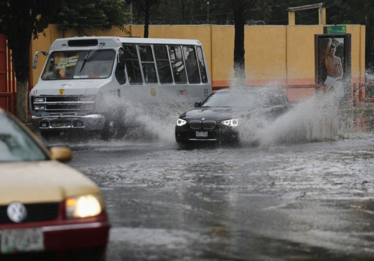 Vehicles drive through a flooded street after torrential rains hit several neighborhoods in Mexico City May 26, 2014. Hurricane Amanda, the first named storm of the Pacific season, moved on Monday losing strength against Mexico's Pacific coast and while s
