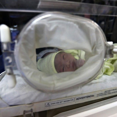 A newborn baby waits for attention at Lima's maternity hospital, May 8, 2014.