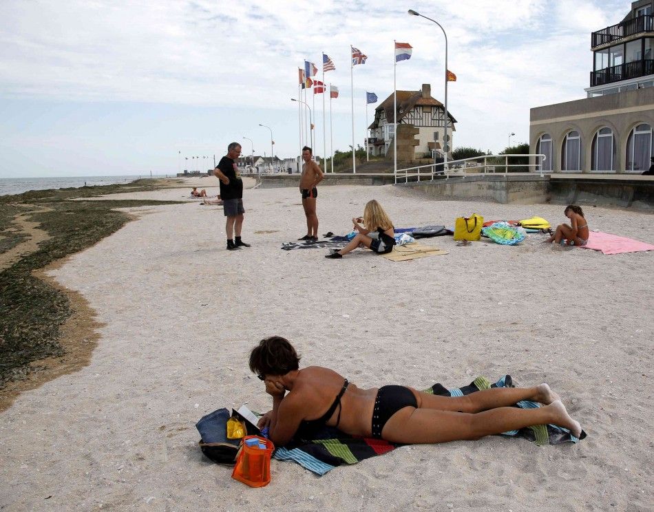 A Tourist Sunbathes on a Former Juno Beach Landing Area Where Canadian Troops Came Ashore on D-Day at Bernieres Sur Mer