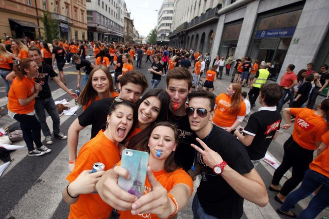 High school graduates take &quot;selfies&quot; on a mobile phone.