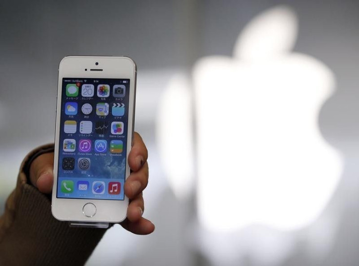 A woman holds her new Apple iPhone 5S after buying it at an Apple Store at Tokyo&#039;s Ginza shopping district