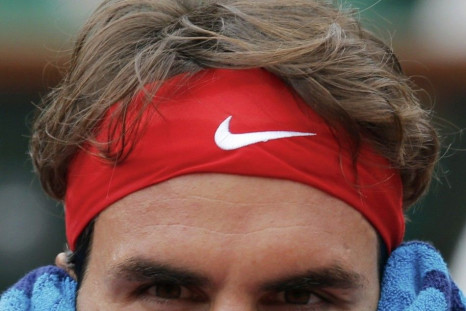 Roger Federer of Switzerland wipes his head with a towel during his men's singles match against Ernests Gulbis of Latvia at the French Open tennis tournament at the Roland Garros stadium in Paris June 1, 2014.