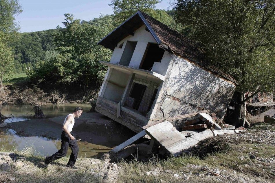 A man walks past a house tilted by floods in the town of Valjevo, southwest from Belgrade May 21, 2014. Picture taken May 21. REUTERSMarko Djurica SERBIA - Tags DISASTER ENVIRONMENT TPX IMAGES OF THE DAY