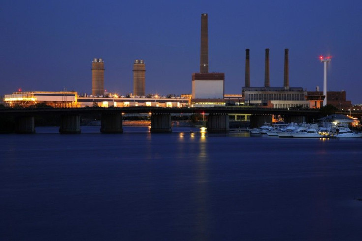 A Massachusetts Water Resources Authority wind turbine (R) turns beside a 2002 megawatt fossil fuel power plant in Charlestown, Massachusetts June 2, 2014. The wind turbine powers the MWRA waste water pumping station at that site and the power plant uses 