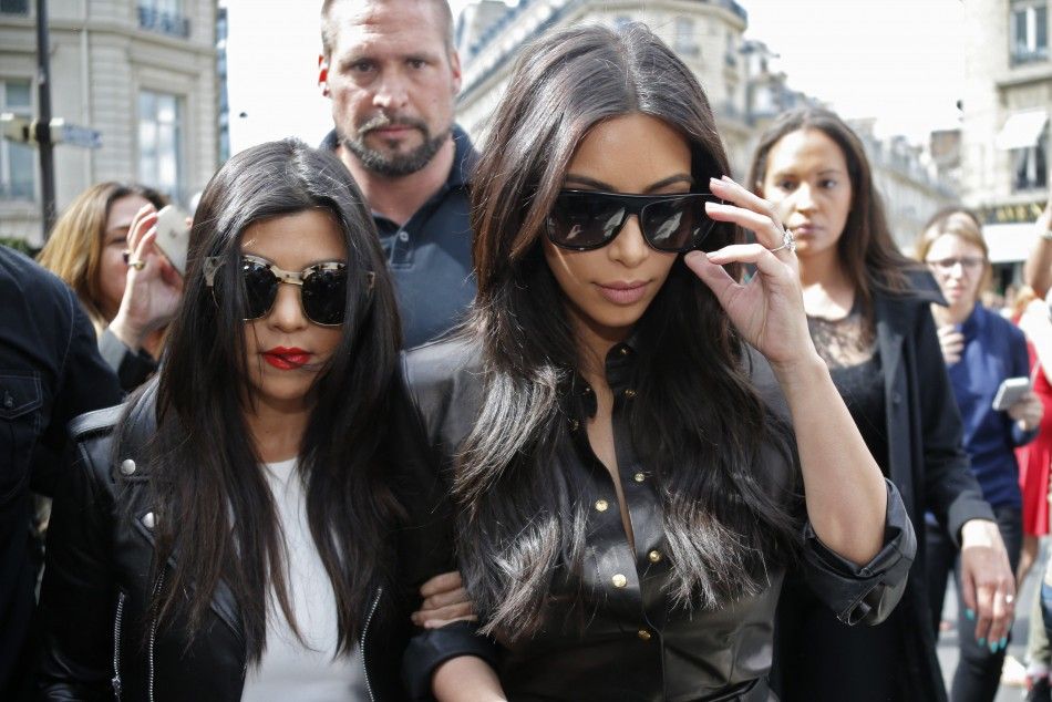 TV personality Kim Kardashian R and her sister Kourtney walk in the street as they visit fashion shops in Paris May 22, 2014.