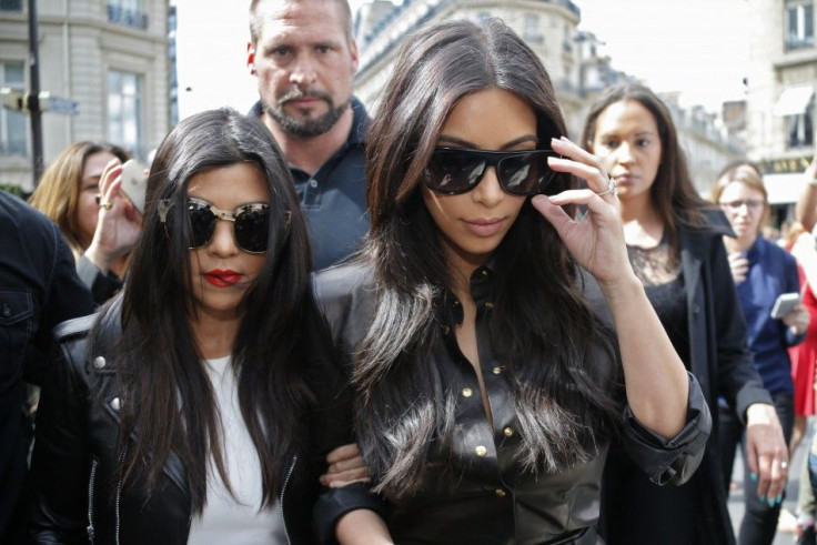TV personality Kim Kardashian (R) and her sister Kourtney walk in the street as they visit fashion shops in Paris May 22, 2014.