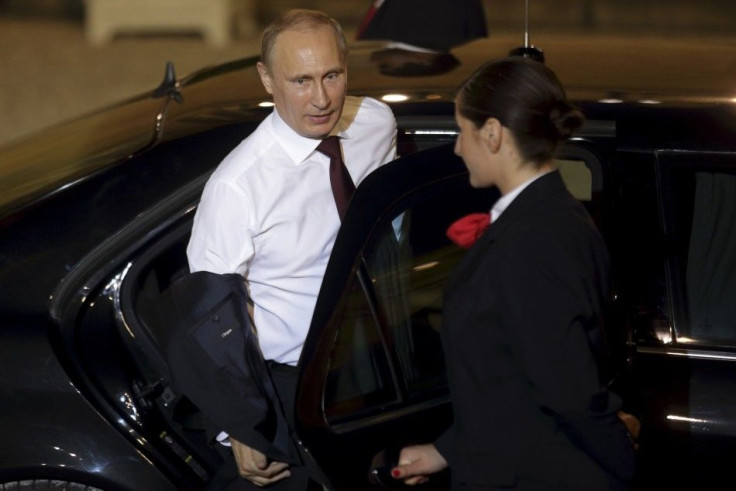 Russian President Vladimir Putin takes off his jacket as he leaves the Elysee Palace in Paris, after a supper with France&#039;s President Francois Hollande