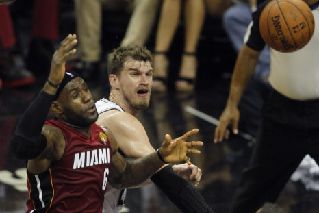 San Antonio Spurs' Tiago Splitter (R) of Brazil knocks the ball out of the hand of Miami Heat's LeBron James during the first quarter in Game 1 of their NBA Finals basketball series in San Antonio, Texas June 5, 2014. 