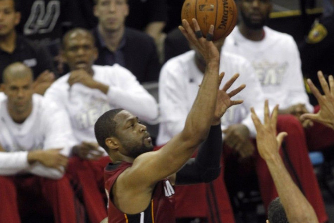 Miami Heat's Dwyane Wade (L) goes up to shoot over San Antonio Spurs' Manu Ginobili during the first quarter in Game 1 of their NBA Finals basketball series in San Antonio, Texas June 5, 2014. 