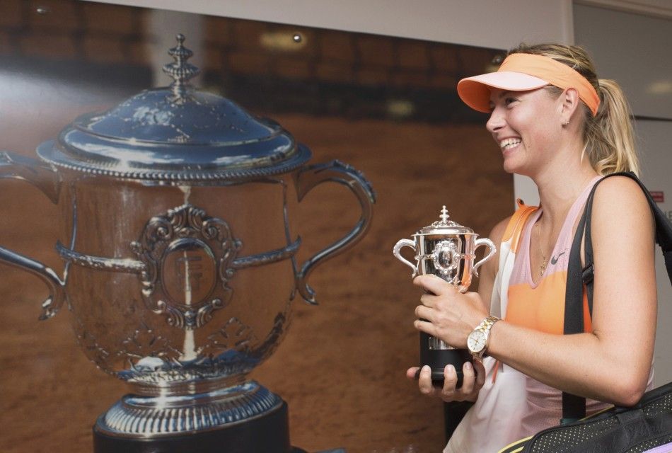 Maria Sharapova of Russia arrives in the dressing room with her trophy after winning the womens singles final match against Simona Halep of Romania during the French Open tennis tournament at the Roland Garros stadium in Paris June 7, 2014.