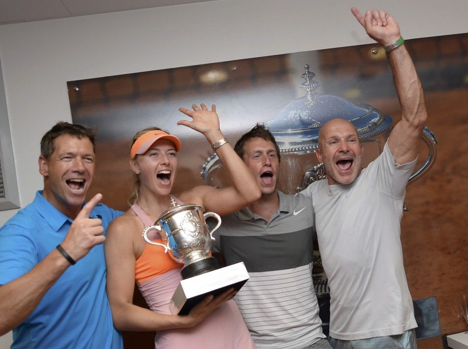 Maria Sharapova of Russia 2ndL holds her trophy as she poses with her coach Sven Groeneveld L and team in the dressing room after winning the womens singles final match against Simona Halep of Romania during the French Open tennis tournament at the R