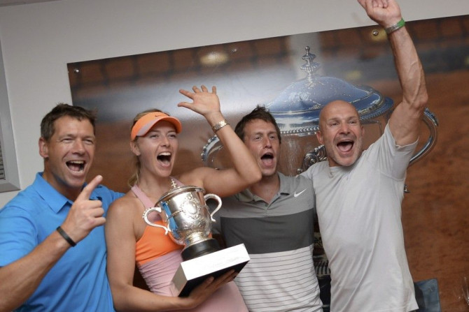 Maria Sharapova of Russia (2ndL) holds her trophy as she poses with her coach Sven Groeneveld (L) and team in the dressing room after winning the women's singles final match against Simona Halep of Romania during the French Open tennis tournament at the R