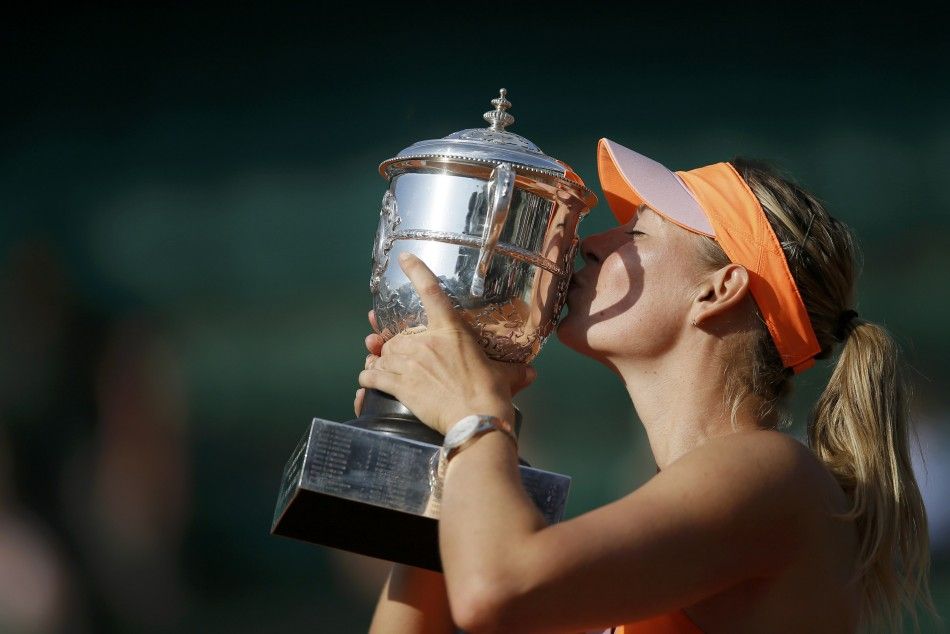 Maria Sharapova of Russia kisses the trophy as she poses during the ceremony after defeating Simona Halep of Romania during their womens singles final match to win the French Open tennis tournament at the Roland Garros stadium in Paris June 7, 2014. 