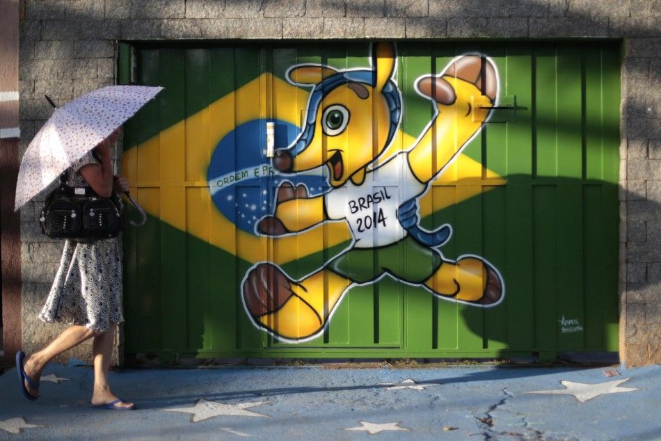 A woman walks past a street wall decorated with graffiti