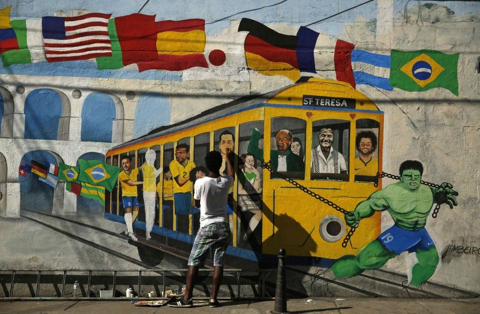 Brazilian artist Jambeiro paints a graffiti in reference to the 2014 World Cup