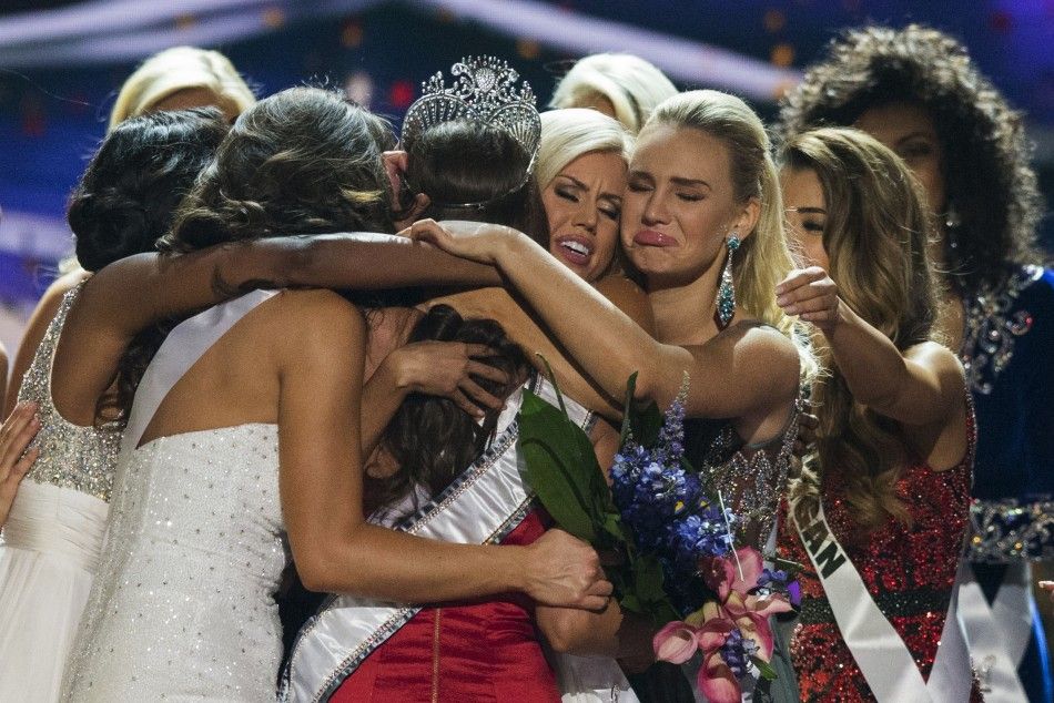 Fellow contestants embrace Miss Nevada Nia Sanchez C after she won the 2014 Miss USA beauty pageant in Baton Rouge, Louisiana