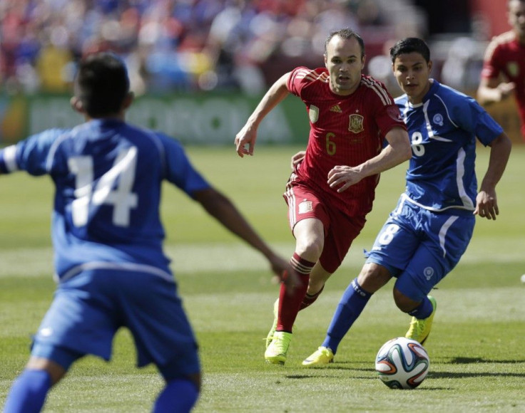 Spain&#039;s Iniesta moves the ball against El Salvador defenders Andres Flores and Kevin Santamaria during the first half of their friendly match in Landover