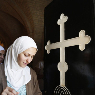 Veiled women walk past door of church in Seidnaya, in west Damascus