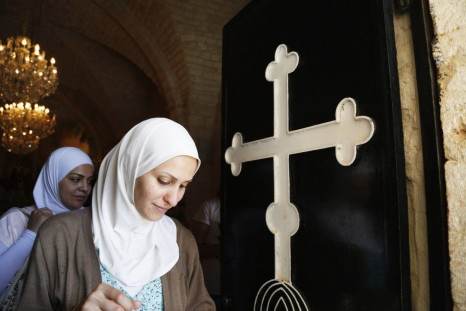 Veiled women walk past door of church in Seidnaya, in west Damascus