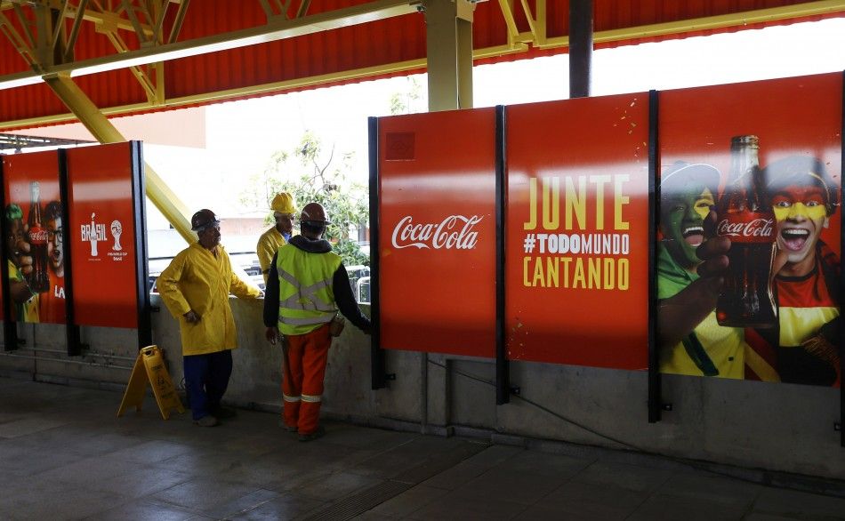 Workers place advertising posters of FIFA sponsors 