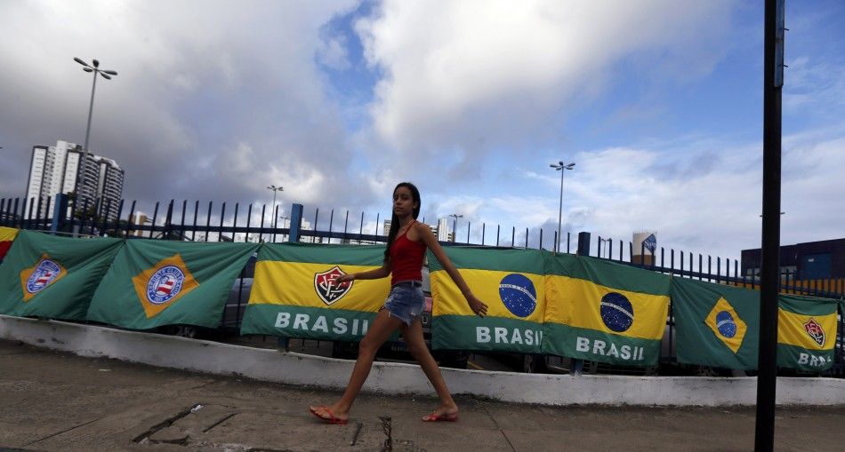 A woman walks in front of Brazilian flags for sale