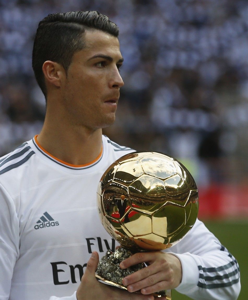 Real Madrids Cristiano Ronaldo holds his Ballon dOr Golden Ball trophy after winning the FIFA World Player of the Year 2013 award, before their Spanish first division soccer match against Granada at the Santiago Bernabeu stadium in Madrid January 25, 