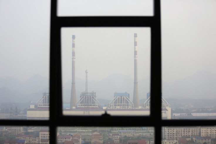 Chimneys are seen through a window at a coal-fired power plant on a hazy day in Shimen county, central China's Hunan Province, June 2, 2014.  