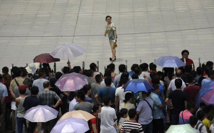 A teacher looks back at family members waiting outside a high school during the national college entrance exam in Wuhan, Hubei province
