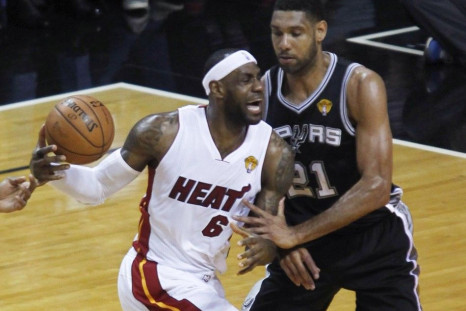 Miami Heat's LeBron James (L) is fouled by San Antonio Spurs' Tim Duncan as he drives to the basket during the first quarter in Game 4 of their NBA Finals basketball series in Miami, Florida, June 12, 2014. 