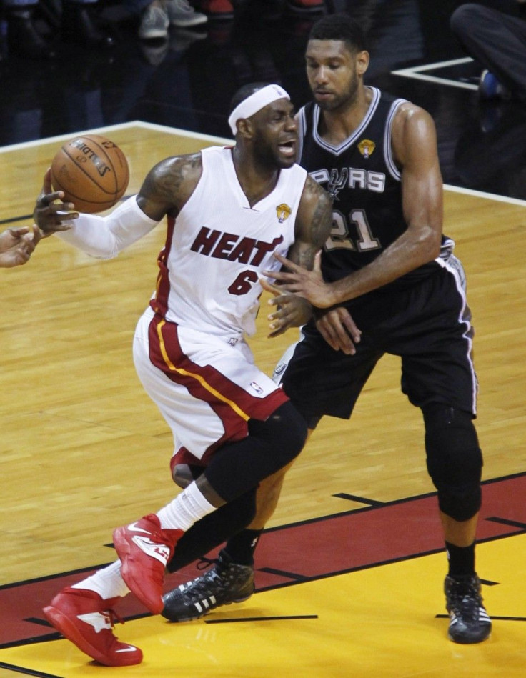 Miami Heat's LeBron James (L) is fouled by San Antonio Spurs' Tim Duncan as he drives to the basket during the first quarter in Game 4 of their NBA Finals basketball series in Miami, Florida, June 12, 2014. 