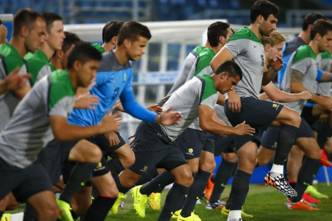 Australia&#039;s national soccer team players Tim Cahill (C) and captain Mile Jedinak (R) run with teammates during a training session in the Arena Pantanal stadium in Cuiaba, June 12, 2014. Australia will play its first match of the 2014 World Cup agains