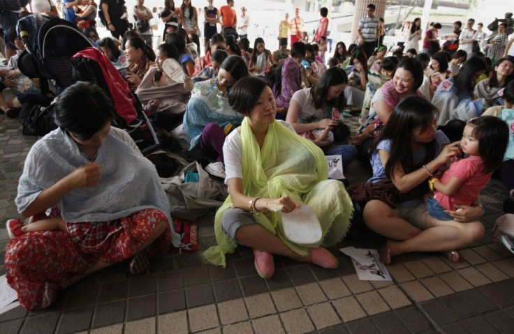 Dozens of mothers take part in a breastfeeding flash mob demonstration at a public place in Hong Kong June 14, 2014.