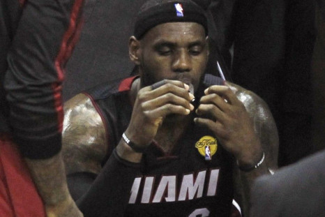Miami Heat's LeBron James sits on the bench during a timeout against the San Antonio Spurs during the second quarter in Game 5 of their NBA Finals basketball series in San Antonio, Texas, June 15, 2014. 