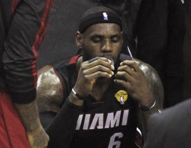 Miami Heat's LeBron James sits on the bench during a timeout against the San Antonio Spurs during the second quarter in Game 5 of their NBA Finals basketball series in San Antonio, Texas, June 15, 2014. 