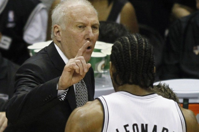 San Antonio Spurs' coach Gregg Popovich (L) talks to Kawhi Leonard during the first quarter in Game 5 of their NBA Finals basketball series against the Miami Heat in San Antonio, Texas, June 15, 2014. 