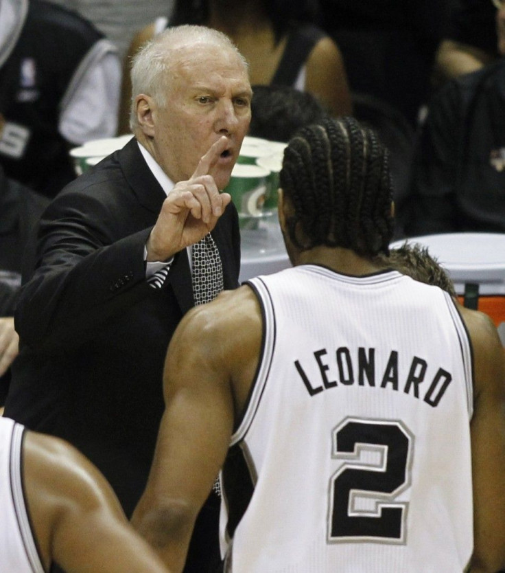 San Antonio Spurs' coach Gregg Popovich (L) talks to Kawhi Leonard during the first quarter in Game 5 of their NBA Finals basketball series against the Miami Heat in San Antonio, Texas, June 15, 2014. 