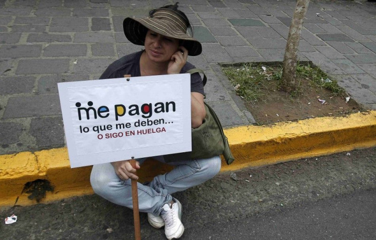 A teacher sits with a placard as she takes part in a march to demand the payment of their salaries from the government in San Jose May 23, 2014. Teachers of public schools and colleges are on an indefinite strike by arrears of their wages for four months,